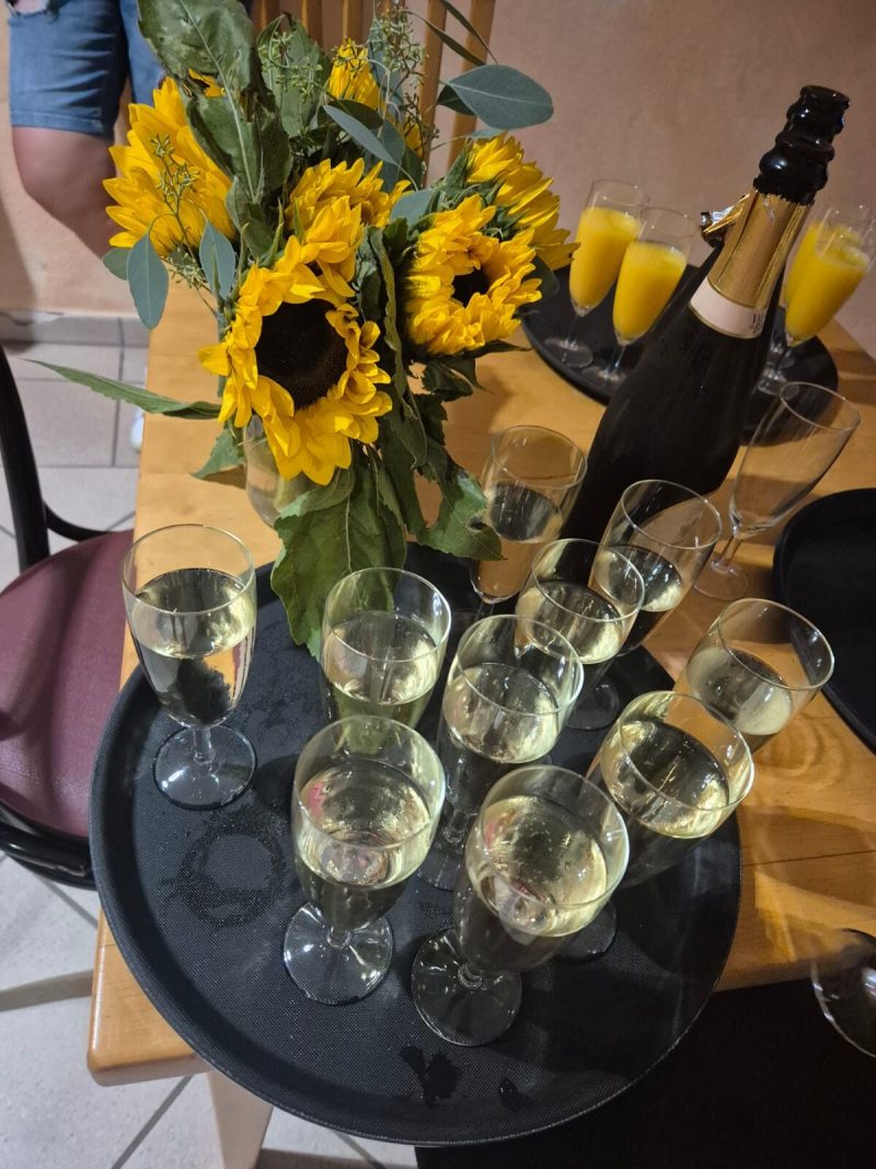 Sektgläser und Sonnenblumen auf dem Empfangstisch zum Sommerfest