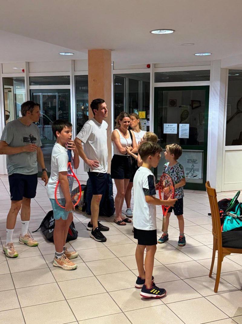 Kinder mit Tennisschlägern vor dem Eingang zur Halle