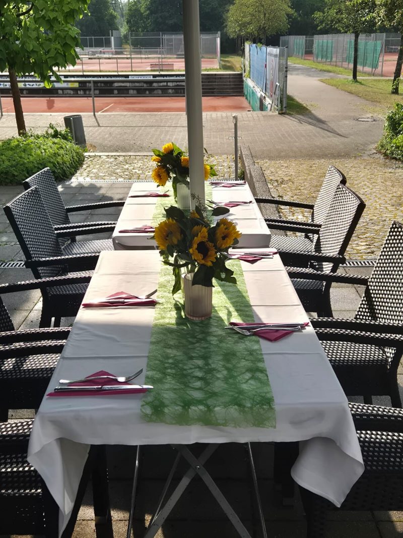 Gedeckte Tafel mit Sonnenblumen vor dem Abend