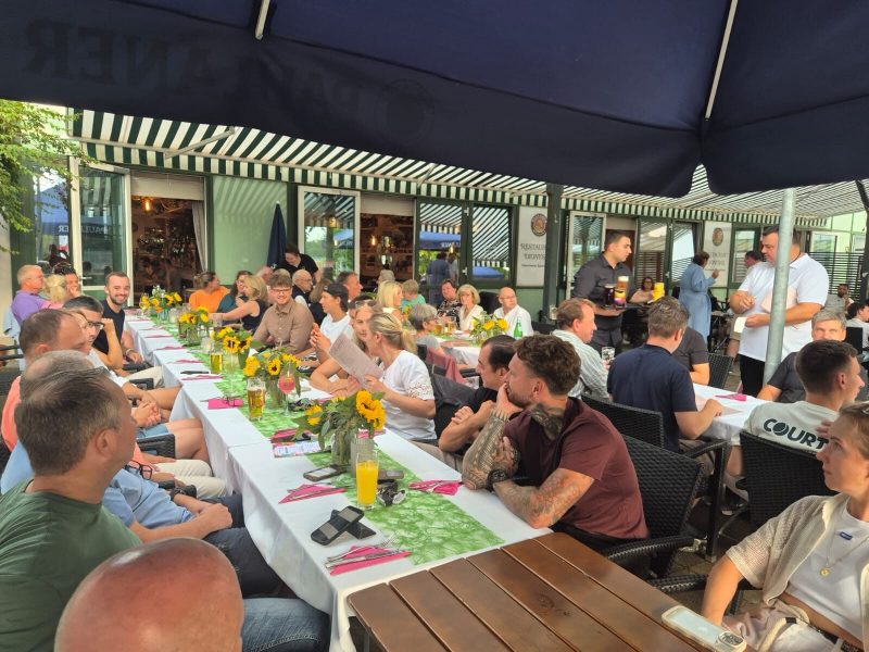 Gäste an der langen Tafel auf der Terrasse